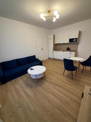 a living room with a blue couch and a table at JD Apartment Sobieskiego in Gniezno