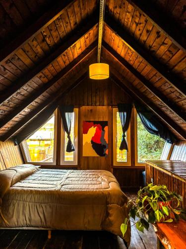 a bedroom with a bed in a room with windows at Alaska Patagonia Hostel in San Carlos de Bariloche