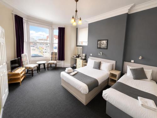 a hotel room with two beds and a living room at Highfield Hotel Blackpool in Blackpool
