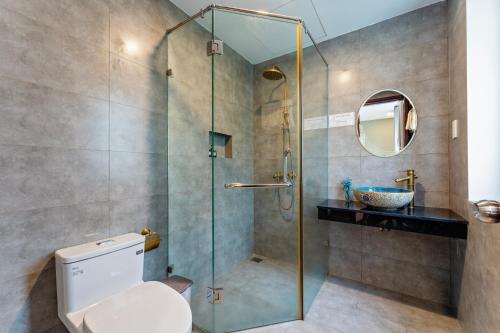 a bathroom with a shower and a toilet and a sink at Buddy January Villa in Hoi An
