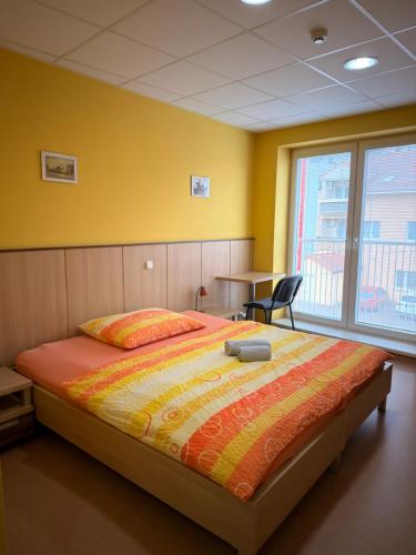 a bedroom with a large bed with a yellow wall at Penzion VV SUN - REOS in Hodonín