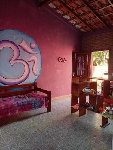 a room with a bed and a painting on the wall at Tahoma Chalé Rustico Lila Prumirim in Ubatuba