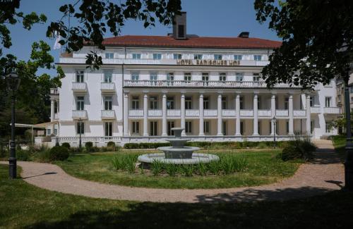a large white building with a fountain in front of it at Badischer Hof Baden-Baden - Leonardo Limited Edition in Baden-Baden