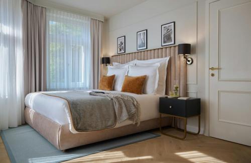 a bedroom with a large bed and a window at Badischer Hof Baden-Baden - Leonardo Limited Edition in Baden-Baden