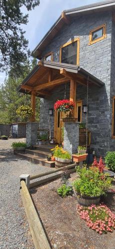 a stone house with potted plants in front of it at Beautiful Riverfront Near Mt Bachelor with Hot Tub in Bend