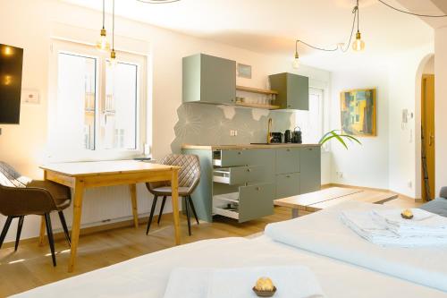 a living room with a table and a desk at Geidorf Residenz - Serviced Apartments & Parking in Graz