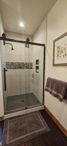 a bathroom with a shower with a glass door at Beautiful Riverfront Near Mt Bachelor with Hot Tub in Bend