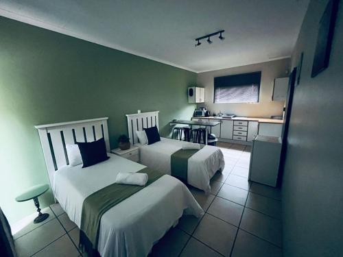 a hotel room with two beds and a kitchen at Marikal Guesthouse in Upington