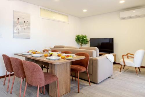 a living room with a table and chairs and a television at Bright & Spacious Flat with Balcony by HostWise in São Mamede de Infesta