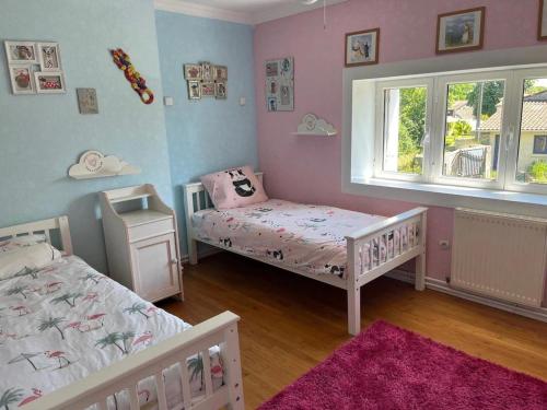 a childs bedroom with two beds and a window at Sleeps10-PrivatePool-GamesRoom-GatedGardens in Paizay-le-Chapt