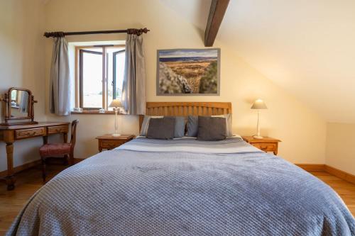 a bedroom with a bed and a desk and a window at Riley Wood Cottage Peaceful Cottage, Views & Walks in Eyam