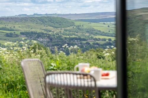 a table and chairs with a view of a valley at Barn Peaceful Stay with Far-Reaching Views in Eyam