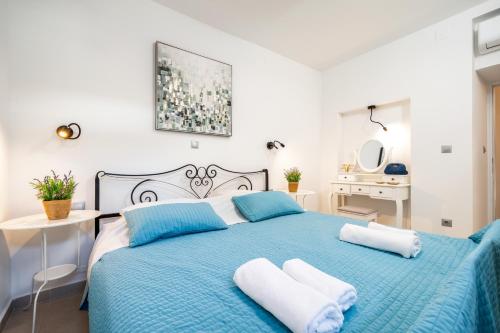 a white bedroom with a blue bed with two pillows at Hvar Villa Maris in Hvar