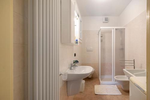 a white bathroom with a sink and a shower at Casa Heidi in Castello Tesino