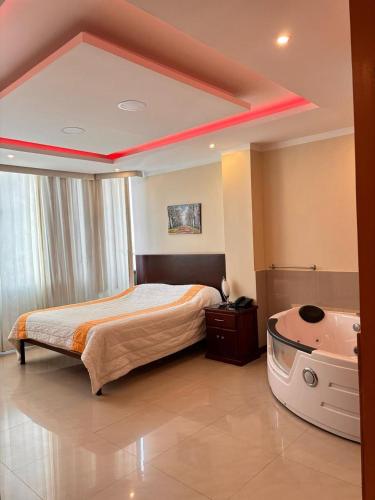 a bedroom with a bed and a bath tub in it at Sol Del Sur Hotel in Huaquillas