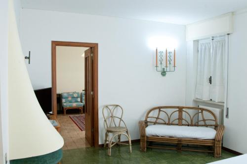 a living room with a bed and two chairs at Hotel Ristorante Maga Circe in San Felice Circeo