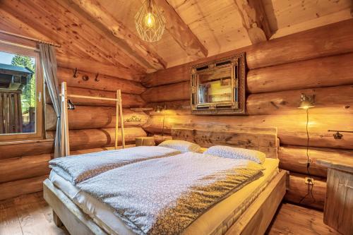 a bedroom with a bed in a log cabin at Chalet 4 in Sankt Englmar