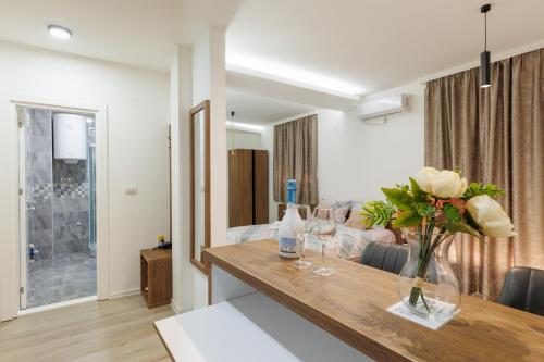 a living room with a table with glasses and flowers at Aqua Apartments 1 in Jagodina