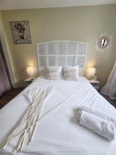 a large white bed with white sheets and pillows at Chambre premium PLUME - jardin - 2p in Sainte-Geneviève-des-Bois