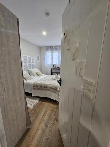 a bedroom with a bed and a room with a door at Chambre premium PLUME - jardin - 2p in Sainte-Geneviève-des-Bois