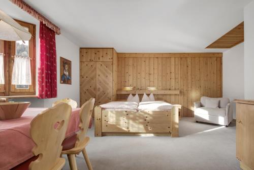 a bedroom with a bed and a couch and a chair at Residence Dolomieu in San Cassiano