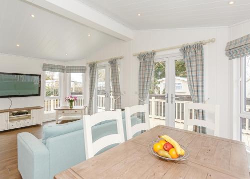a living room with a table with a bowl of fruit at Talacre Beach Resort in Talacre