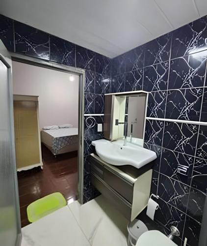 a bathroom with a sink and a mirror at Dourados Guest Flat, your choice in Dourados-MS. in Dourados