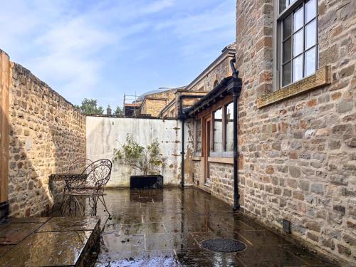 a patio with a table and chairs in the rain at West House - Uk51668 in Leyburn