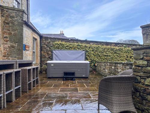 a outdoor patio with a tv on a brick wall at West House - Uk51668 in Leyburn