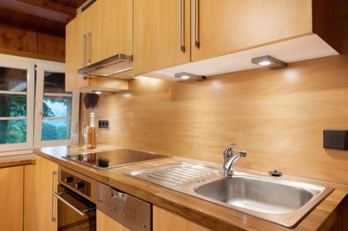 a kitchen with a stainless steel sink and wooden cabinets at Reesbauernhof - Fewo Abendrot in Oberried