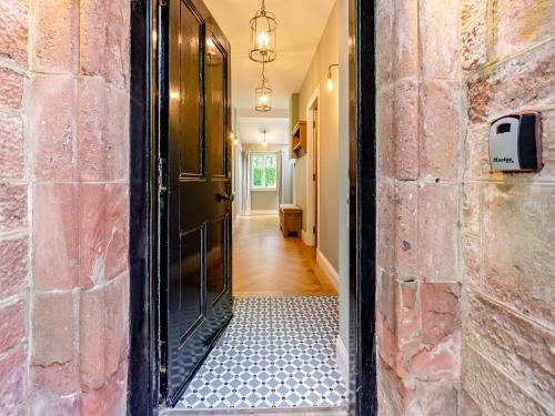 a hallway with a door and a brick wall at West Lodge in Perth
