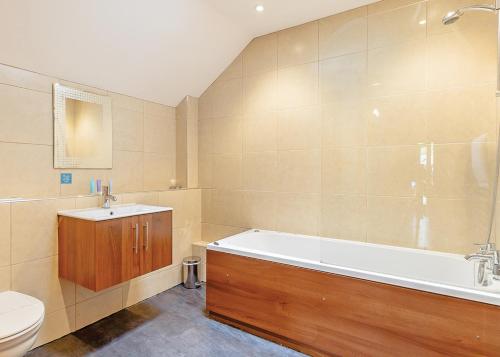 a bathroom with a tub and a toilet and a sink at Tilford Woods Lodge Retreat in Hurley