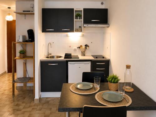 a kitchen with a table with two plates on it at Studio centre-ville avec ascenseur - Le Mistral in Digne-les-Bains