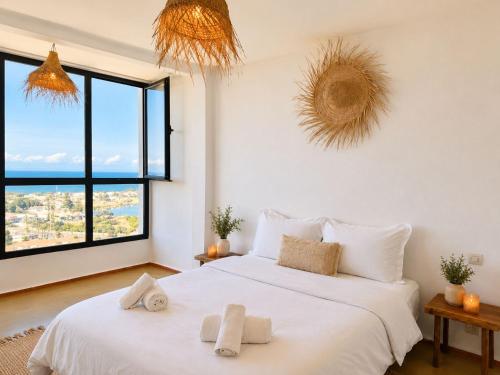 a bedroom with a large white bed with towels on it at Appartement LE SABLE Uniquement les familles in Oualidia
