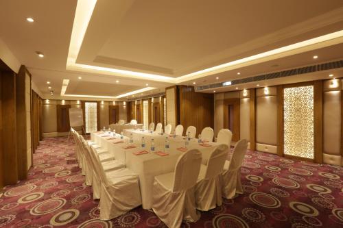 a conference room with a long table with white tables and chairs at Ramada Encore Jalandhar in Jalandhar