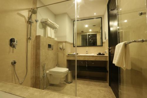 a bathroom with a shower and a toilet and a sink at Ramada Encore Jalandhar in Jalandhar