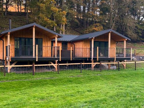 a log cabin with a grass field in front of it at Lakeside Lodge - Uk50627 in Welshpool
