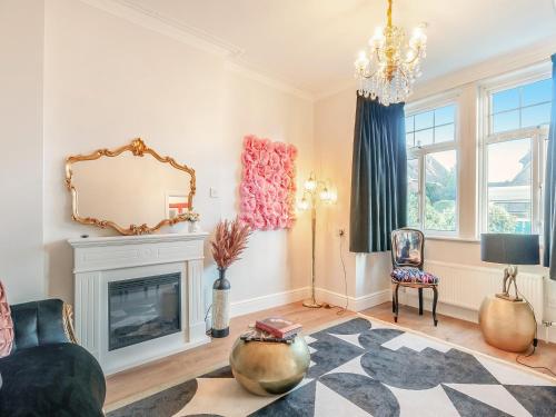a living room with a fireplace and a mirror at The Old Doctors Manor House in Whitstable