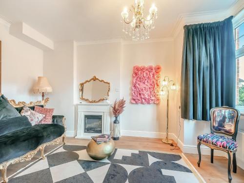 a living room with a couch and a fireplace at The Old Doctors Manor House in Whitstable