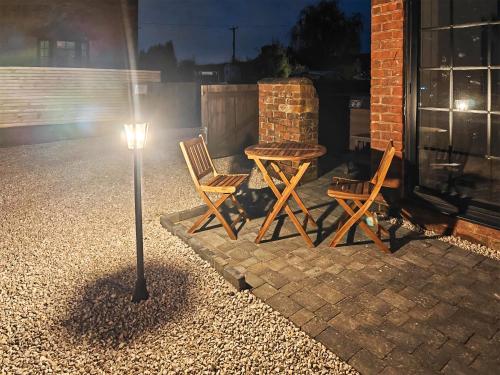 two chairs and a table on a patio at Fountain Front Barn - Uk45937 in Corley