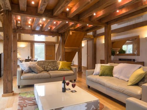 a living room with two couches and a table at Coot Lodge in Somerford Keynes