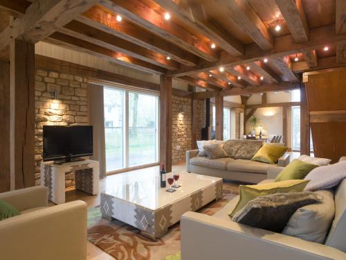 a living room with couches and a tv at Coot Lodge in Somerford Keynes