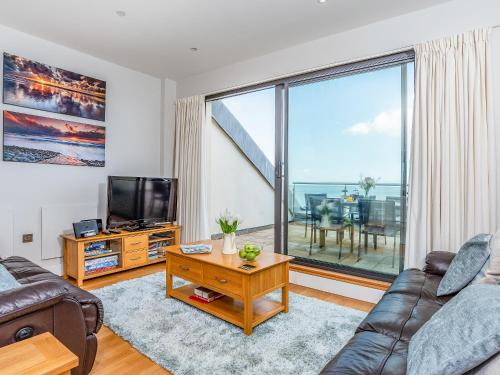 a living room with a couch and a large window at Sand Dunes in Westward Ho