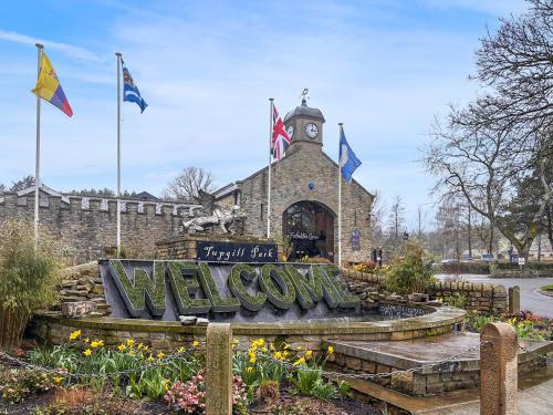 a welcome sign in front of a building with a clock tower at Ghyll Cottage - Uk51667 in Leyburn