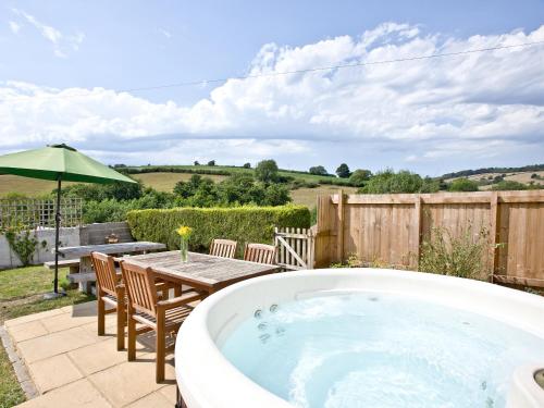 a hot tub in a yard with a table and chairs at Endeavour - Hhy in Luton
