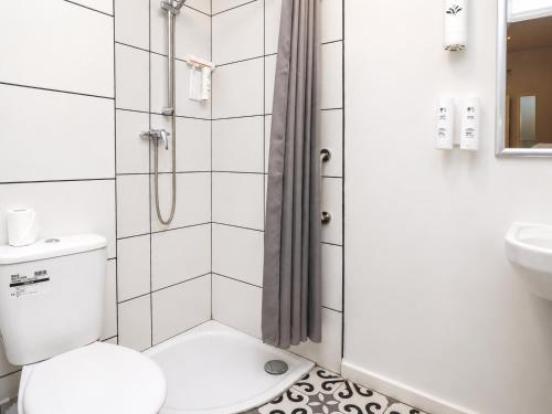 a bathroom with a shower with a toilet and a sink at Highfield Hotel Blackpool in Blackpool