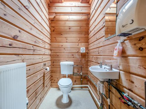 a wooden bathroom with a toilet and a sink at Lodge - Uk49989 in Blandford Forum