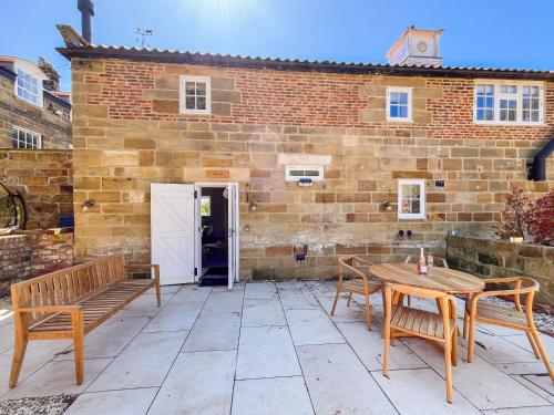 a patio with two benches and a table and a building at Stables - Uk51829 in Great Ayton