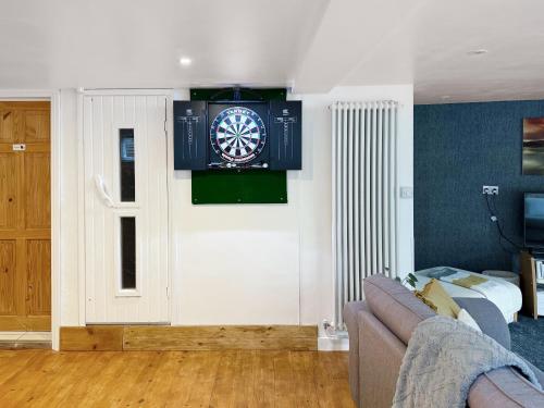 a living room with a dart board on the wall at The Spinney in Carterton