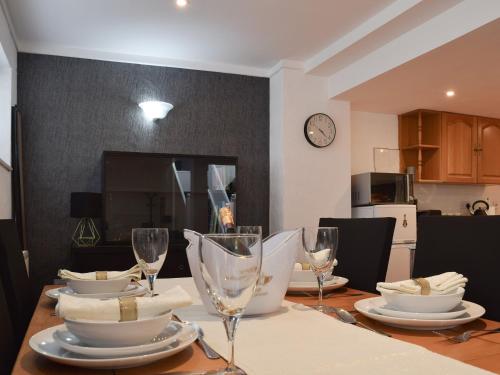 a dining room table with glasses and plates on it at The Spinney in Carterton